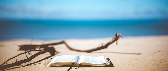 book in front of the ocean on the beach