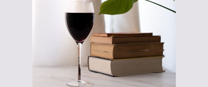 glass of wine and stack of books