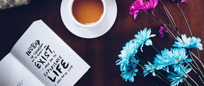 open book with an inspiring quote, flowers, and coffee