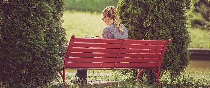 woman reading a book on a bench