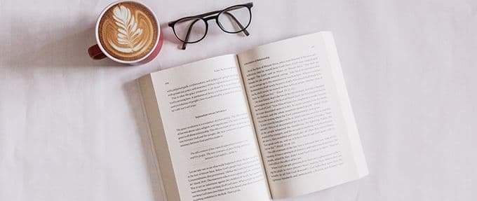 open book with latte and glasses